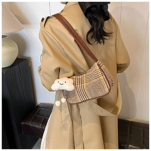 Close-up of retro plaid underarm bag with cute cloud charm and brown leather strap