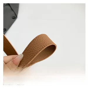 Close-up of brown litchi pattern leather shoulder strap with detailed stitching
