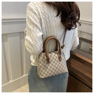 Detailed side view of a vintage shell crossbody bag with geometric print and leather strap