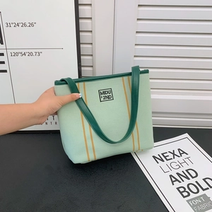 Minimalist light green canvas tote bag with dark green handles and Midu embroidery