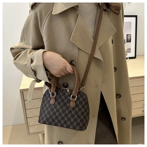 Elegant vintage monogram shell bag shown with a tan trench coat by a female model