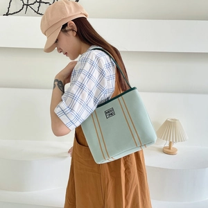 Minimalist light green canvas tote bag with brown vertical stripes and top handle strap
