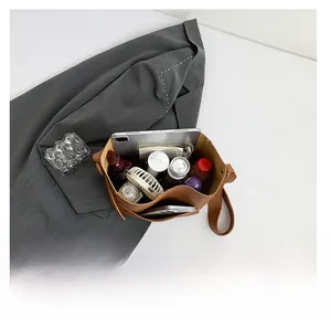 Interior view of large brown tote bag showing spacious capacity with tablet and daily items