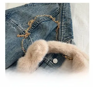 Détail du sac à main en fausse fourrure beige avec anses en peluche et chaîne dorée