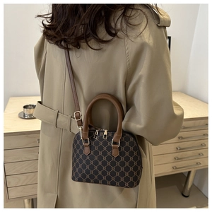 Detail of vintage patterned shell bag with golden hardware and adjustable leather strap
