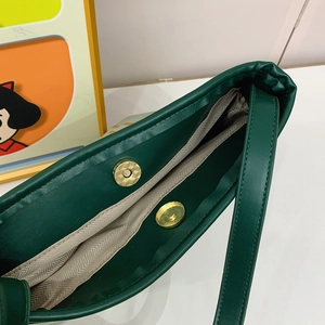 Deep green leather bucket bag with magnetic closure and herringbone fabric lining inside