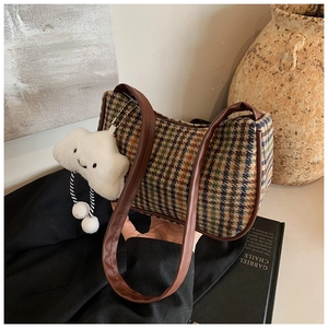Detail of tweed checkered underarm bag with plush cloud charm and brown faux leather strap