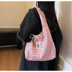 Detail of pink plaid canvas tote bag with cherry patch and yellow bow decoration