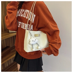 Detail of cream corduroy tote bag featuring a cute cloud pendant and brand logo