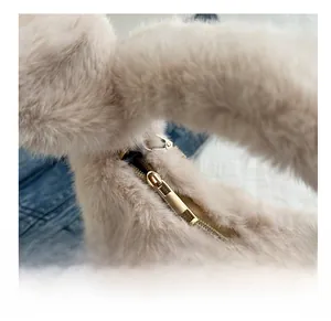 Détail de la fermeture éclair dorée fluide sur ce sac à bandoulière en peluche beige