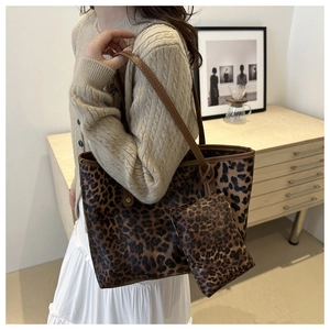 Detailed view of leopard print tote bag with matching zipper pouch on a wooden table
