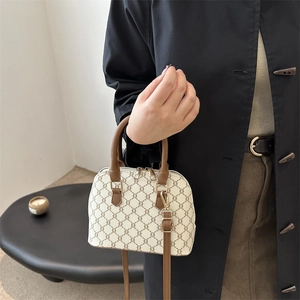 Minimalist beige shell dome bag with vintage monogram and brown leather handles