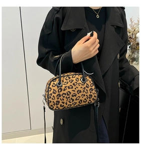 Detail of leopard print mini Boston bag with black handles and detachable shoulder strap