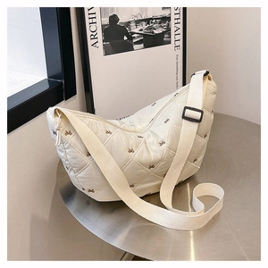 Detailansicht der cremefarbenen Stepptasche mit feiner brauner Schleifenstickerei