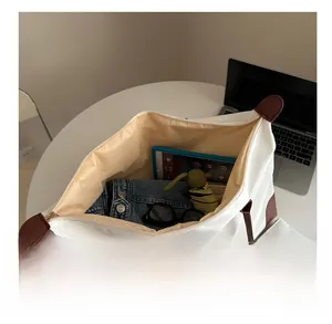 Top view of large capacity white tote bag interior with iPad, umbrella and sunglasses