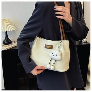Detail of off-white waffle texture shoulder bag with brown leather straps and cloud charm
