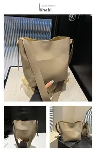 Detail of khaki bucket bag showing large lychee texture and wide shoulder strap for women