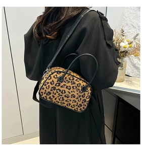 Fashionable leopard print crossbody bag worn by model in a minimalist stylish indoor setting