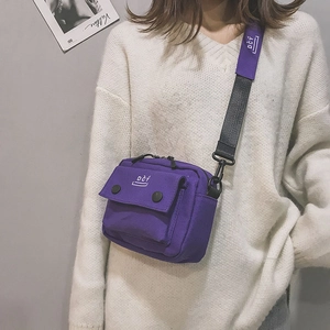 Close-up of a purple canvas crossbody bag showing durable texture and white DCY logo