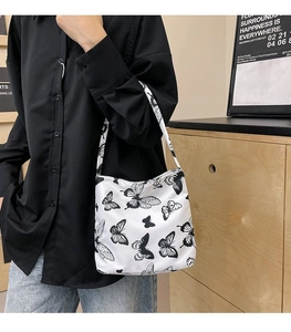 Détail du sac cabas en toile à imprimé papillon porté avec une tenue décontractée