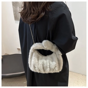 Détail du sac à main en fausse fourrure grise avec élégante bandoulière en chaîne dorée
