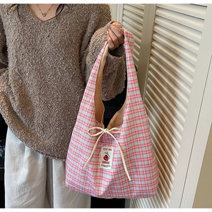 Detail of blue plaid canvas tote with drawstring and red tomato embroidery tag
