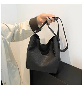 Close-up of black litchi grain leather bucket bag with soft texture and shoulder strap