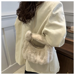 Détail du sac à main en fausse fourrure beige avec poignée nouée et chaîne dorée