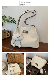 Detailed macro view of textured corduroy tote bag with brown straps and plush cloud charm