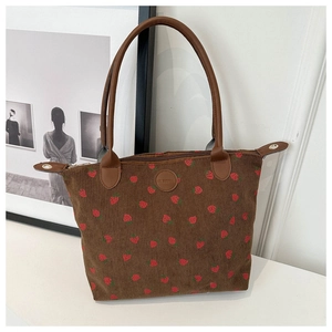 Detail of strawberry print on brown corduroy tote bag with durable PU leather handles
