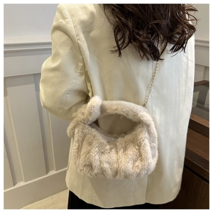 Détail du sac bandoulière en fausse fourrure beige avec chaîne en métal doré élégante