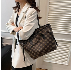 Dettaglio della borsa tote vintage con stampa geometrica marrone e tracolla in pelle nera
