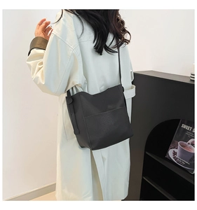 Detailed side view of black lychee grain leather bucket bag with shoulder strap