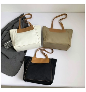 Detailed overhead view of large canvas tote bags in white, khaki, and black colors