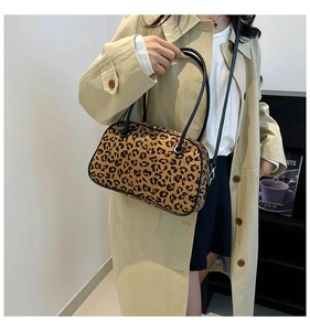 Detail of leopard print tote bag with black leather straps styled with a trench coat
