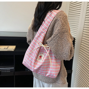 Detail of blue and pink checkered canvas tote bag with ribbon and handmade woven label