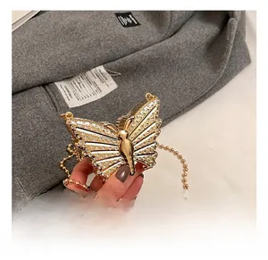Detail of a golden butterfly evening bag with rhinestones and a metal chain strap