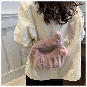 Détail du sac à main en peluche rose avec fourrure douce et chaîne dorée élégante