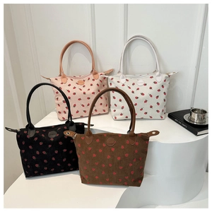 Close-up of strawberry print corduroy tote bags with leather handles in four colors