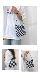 Détail du grand sac cabas en toile à damier porté à l'épaule et à la main
