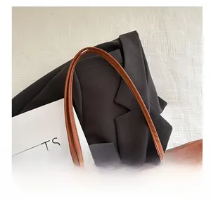 Detail showing brown leather handles and leopard print texture on the tote bag