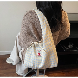 Detail of checkered tote bag with tomato label and decorative bow tie closure