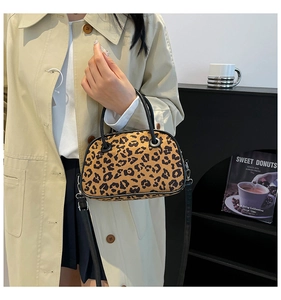 Detail of leopard print handbag with round black handles and silver metal hardware