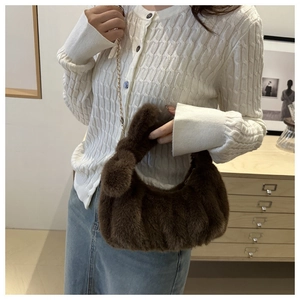 Vue détaillée du sac à main en peluche marron avec chaîne dorée et texture douce