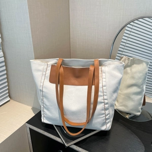 Minimalist large canvas tote bag with brown leather trim for women's daily commute use