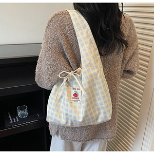 Detail of yellow and blue plaid canvas tote bag with bow tie and handmade label