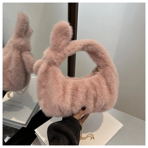 Détail d'un sac à main en peluche rose montrant la texture douce et la chaîne dorée