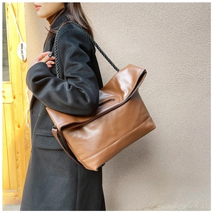 Detailed view of brown PU leather shoulder bag with unique woven rope strap detail