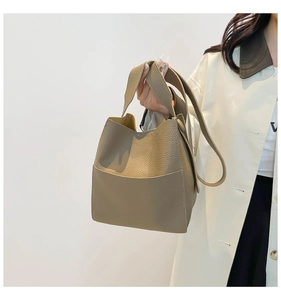 Detail of khaki bucket bag with lychee pattern leather and adjustable shoulder strap