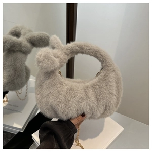 Détail d'un sac à main gris en fausse fourrure avec texture peluche et chaîne dorée femme
